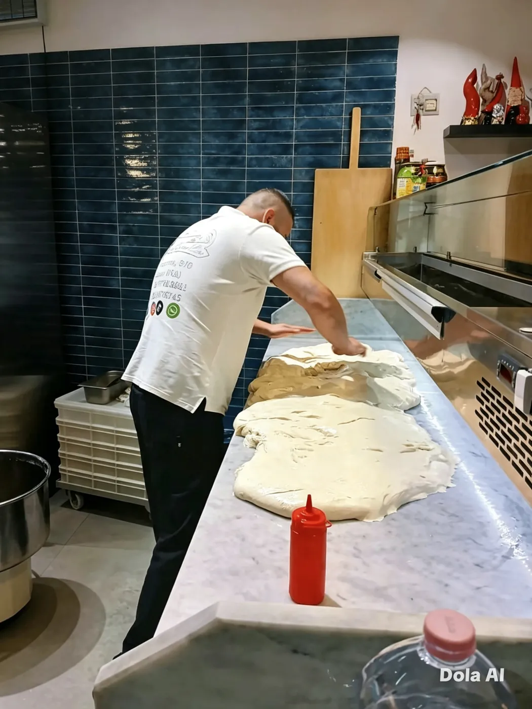 Pizzaiolo che stende l'impasto sul bancone di marmo